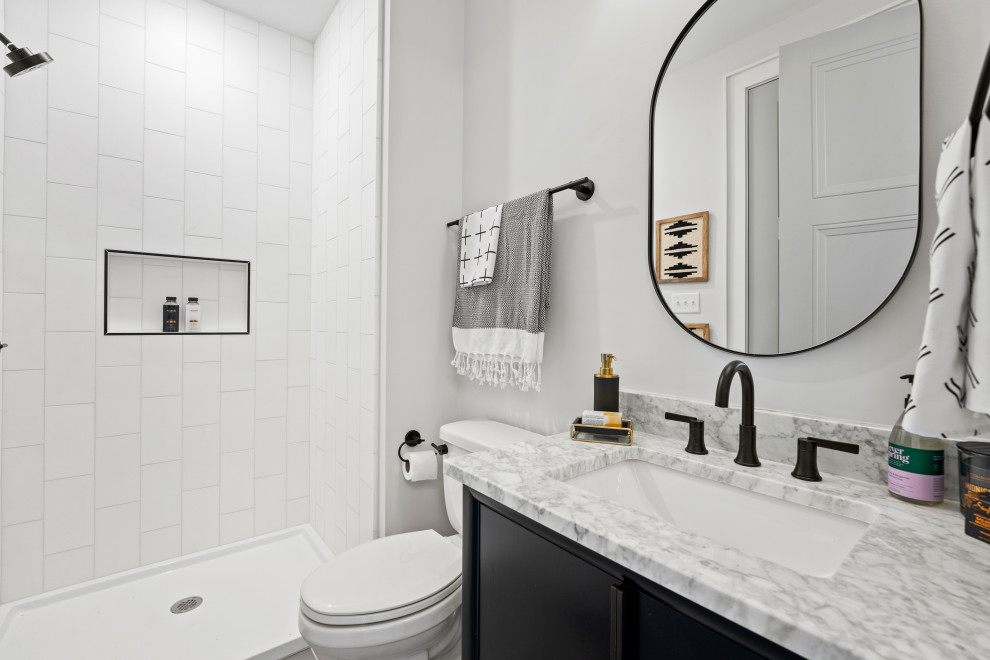 This is an example of a mid-sized contemporary 3/4 bathroom in Richmond with furniture-like cabinets, black cabinets, an alcove shower, a one-piece toilet, white tile, stone tile, white walls, ceramic floors, an undermount sink, marble benchtops, grey floor, an open shower, multi-coloured benchtops, a niche, a single vanity and a built-in vanity.