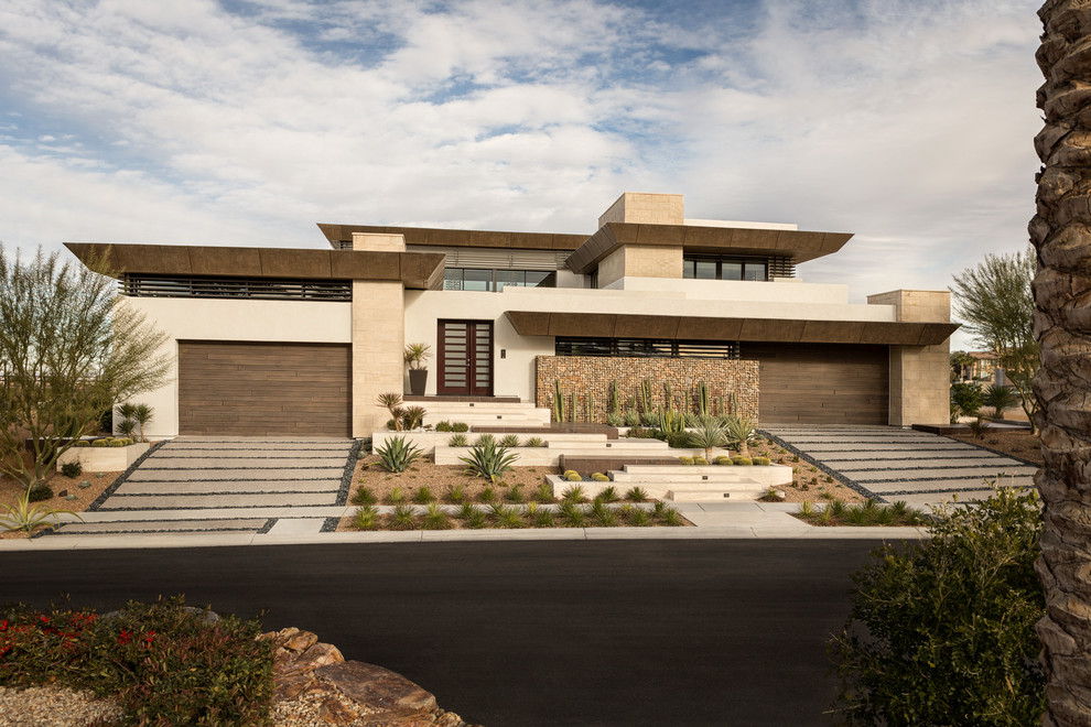Inspiration for an expansive contemporary three-storey beige house exterior in Las Vegas with a flat roof.