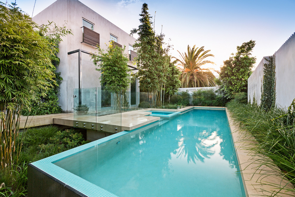 Contemporary custom-shaped infinity pool in Melbourne with concrete pavers.