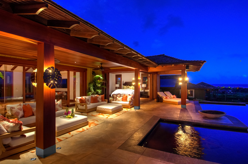 Inspiration for a huge tropical backyard tile and custom-shaped infinity patio remodel in Hawaii with a fire pit and a roof extension