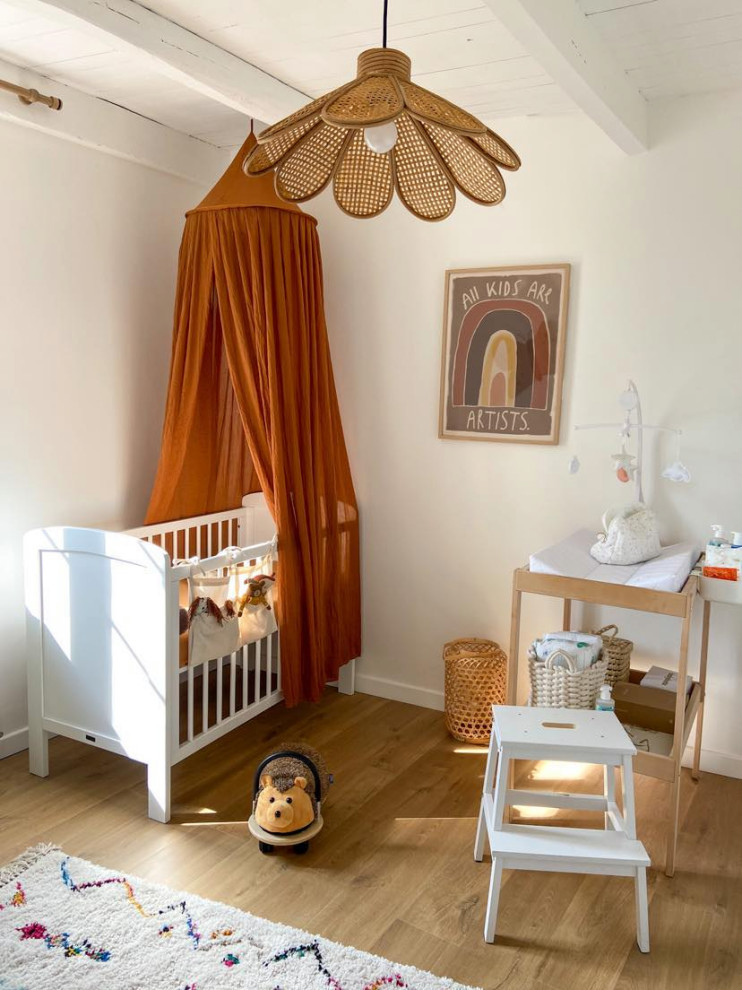 Cette photo montre une chambre de bébé fille nature de taille moyenne avec un mur blanc, parquet clair, un sol marron et un plafond en bois.