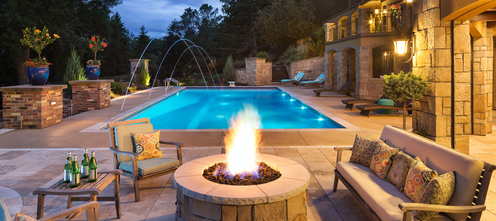 Photo of a large mediterranean backyard rectangular lap pool in Minneapolis with concrete pavers and a hot tub.