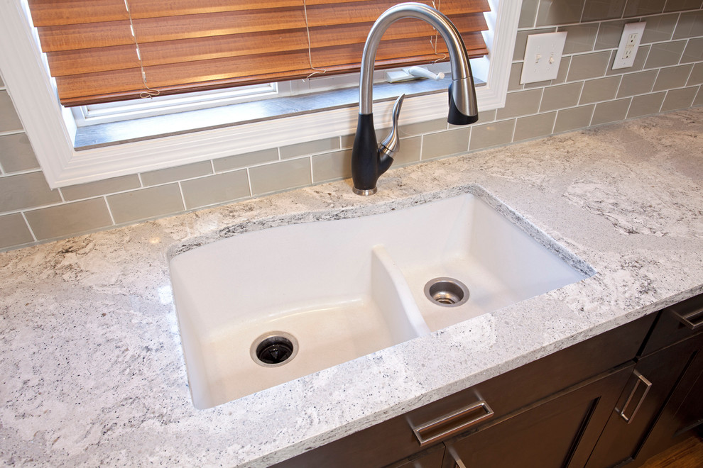 Example of a mid-sized transitional u-shaped medium tone wood floor eat-in kitchen design in Minneapolis with an undermount sink, flat-panel cabinets, dark wood cabinets, gray backsplash, glass tile backsplash, stainless steel appliances and a peninsula