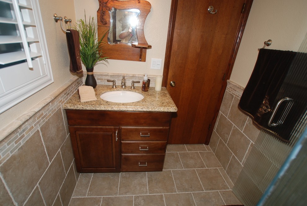 Small minimalist 3/4 beige tile and porcelain tile porcelain tile corner shower photo in Orange County with an undermount sink, raised-panel cabinets, dark wood cabinets, granite countertops, a two-piece toilet and beige walls