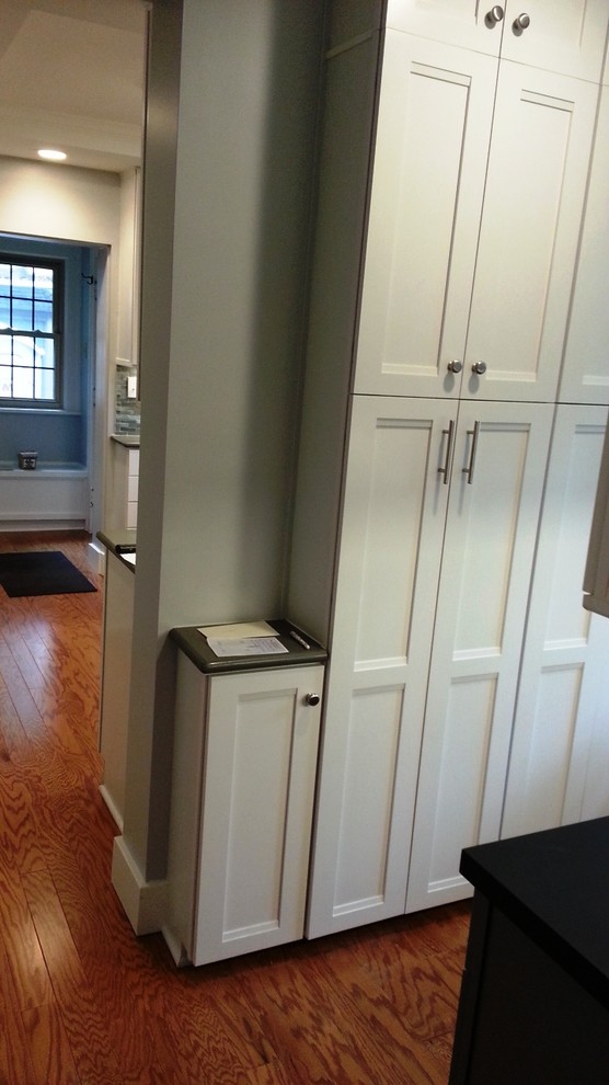 Inspiration for a mid-sized transitional u-shaped dark wood floor and brown floor enclosed kitchen remodel in Cleveland with an undermount sink, shaker cabinets, white cabinets, quartz countertops, gray backsplash, mosaic tile backsplash, stainless steel appliances, no island and gray countertops