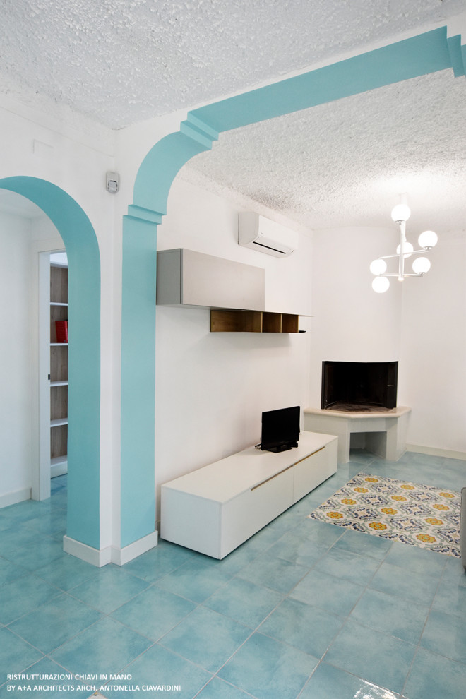 Стильный дизайн: открытая гостиная комната среднего размера в средиземноморском стиле с белыми стенами, полом из керамогранита, угловым камином, фасадом камина из плитки, мультимедийным центром, бирюзовым полом и ковром на полу - последний тренд