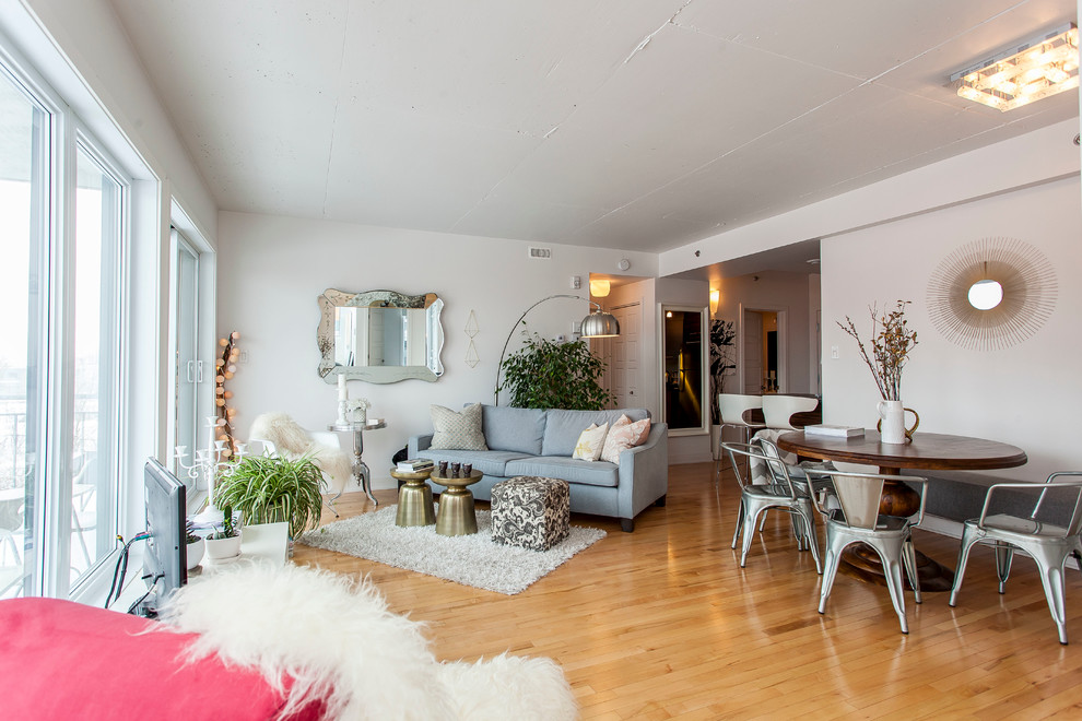 Inspiration for a scandinavian medium tone wood floor living room remodel in Montreal with white walls, no fireplace and a tv stand