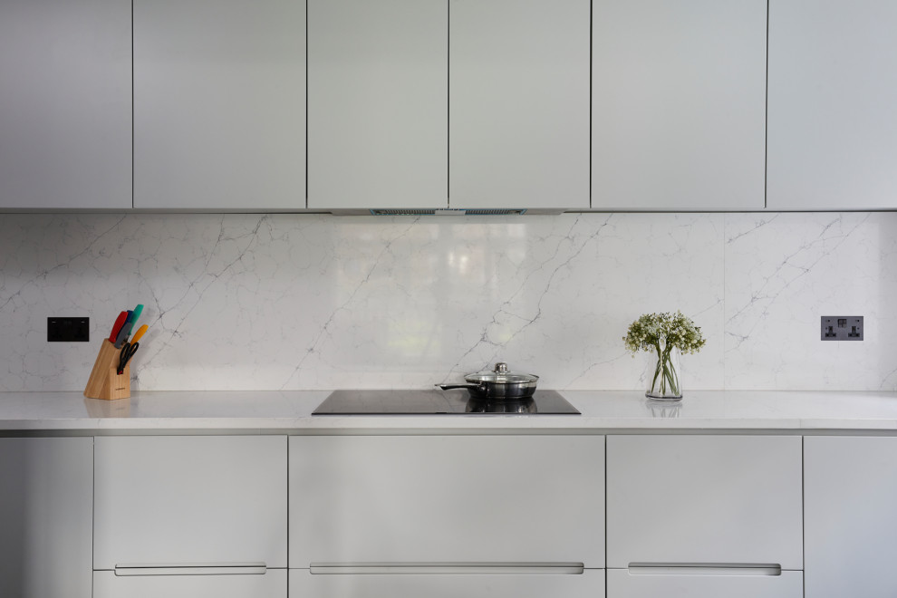 Mid-sized modern u-shaped separate kitchen in London with flat-panel cabinets, grey cabinets, marble benchtops, grey splashback, marble splashback, panelled appliances, no island and grey benchtop.