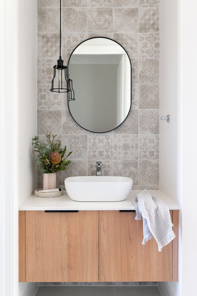 Idée de décoration pour un petit WC et toilettes en bois clair avec un plan de toilette en quartz modifié et meuble-lavabo encastré.