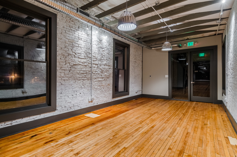 Inspiration for a large industrial hallway in Baltimore with grey walls and light hardwood floors.