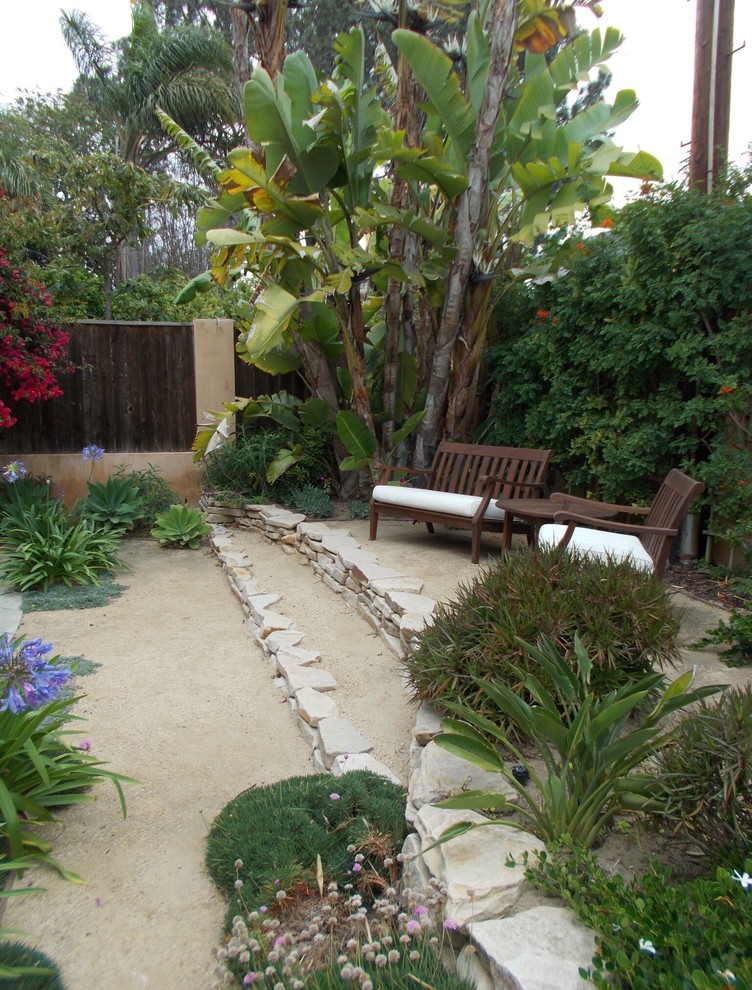 Design ideas for a mid-sized tropical backyard full sun garden in Los Angeles with gravel.