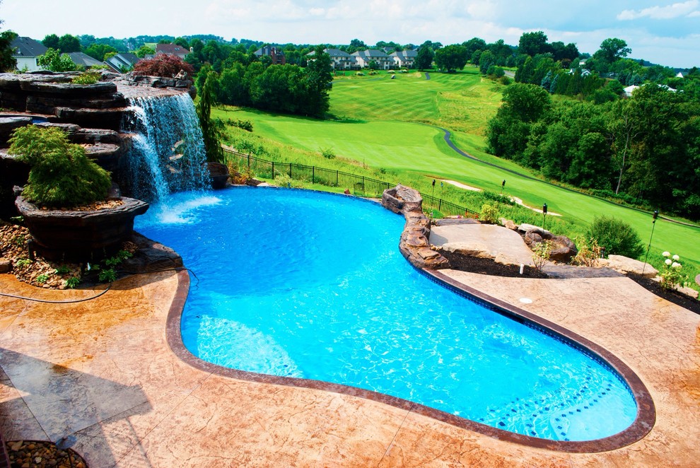 Large mountain style backyard stamped concrete and custom-shaped natural pool fountain photo