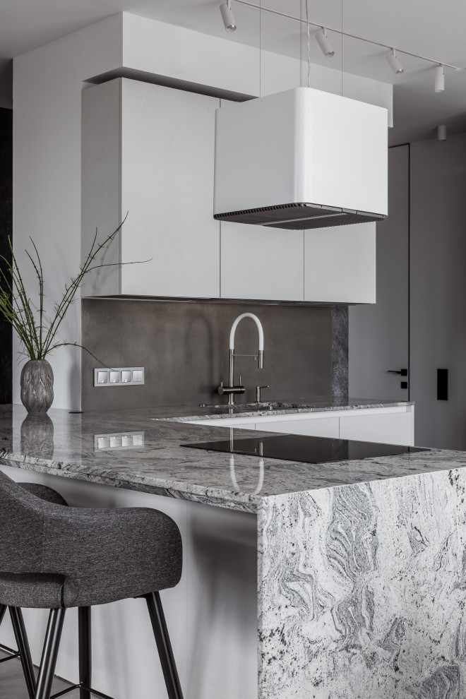 Inspiration for a contemporary l-shaped open plan kitchen in Other with an undermount sink, flat-panel cabinets, white cabinets, granite benchtops, grey splashback, metal splashback, black appliances, vinyl floors, with island, grey floor and grey benchtop.