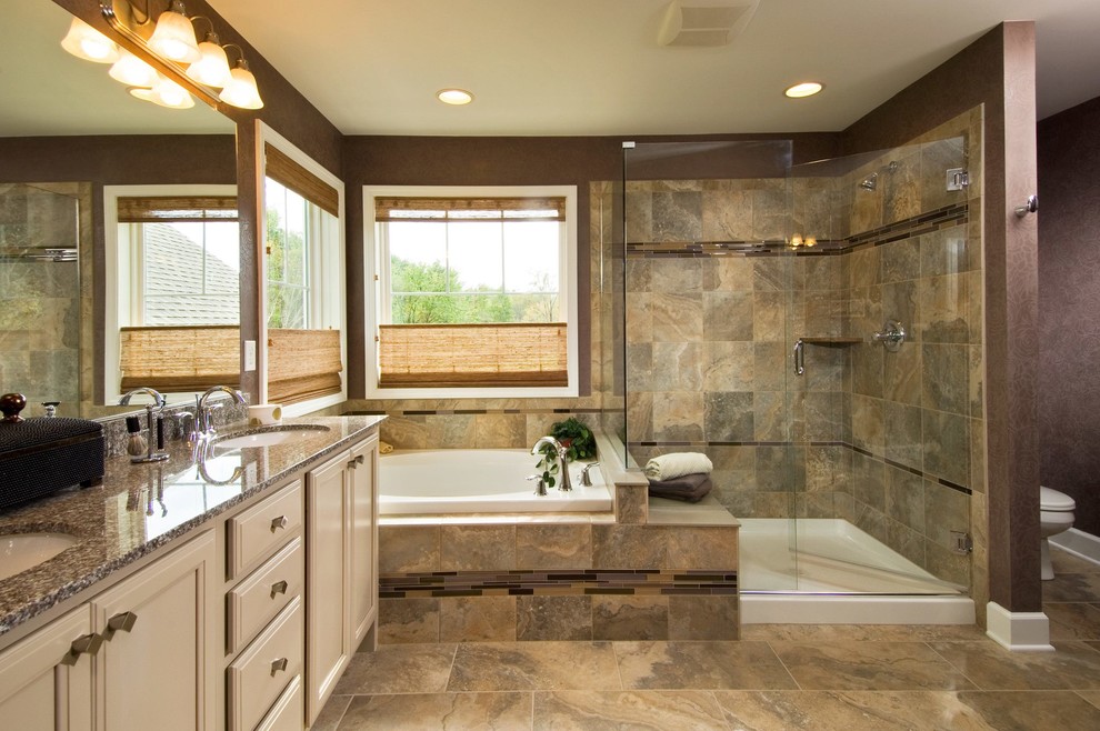 This is an example of a traditional bathroom in Boston with granite benchtops and brown floor.