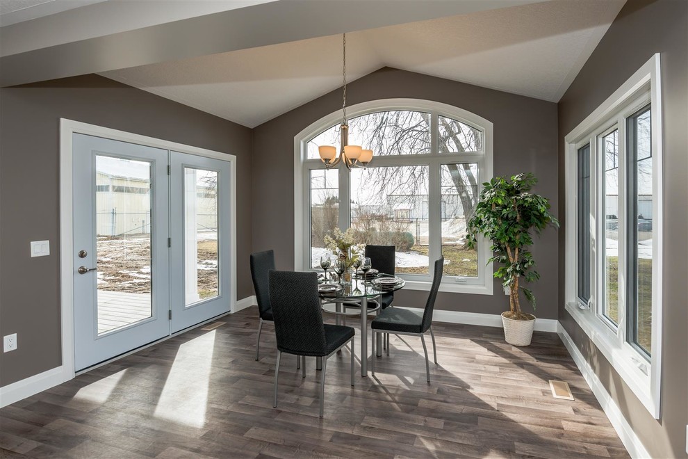 Large transitional medium tone wood floor and brown floor great room photo with brown walls and no fireplace