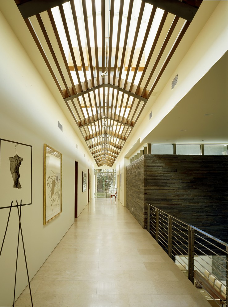 Contemporary hallway in Los Angeles with white walls and limestone floors.