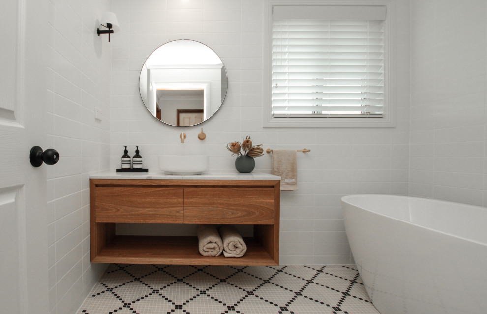 Modern inredning av ett mellanstort en-suite badrum, med skåp i mellenmörkt trä, ett fristående badkar, en öppen dusch, vit kakel, ett fristående handfat och med dusch som är öppen