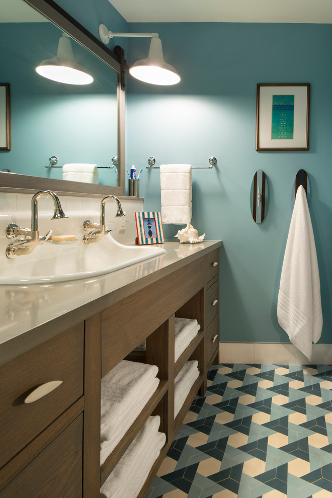 This is an example of a mid-sized beach style bathroom in Miami with flat-panel cabinets, medium wood cabinets, white tile, ceramic tile, blue walls, cement tiles, a trough sink, engineered quartz benchtops and blue floor.