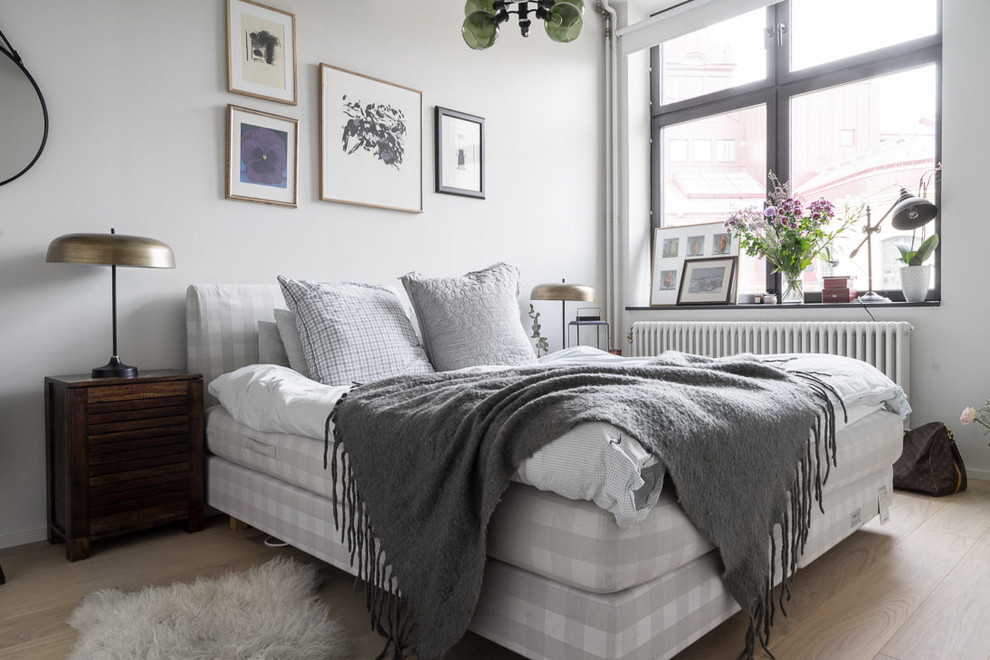 Mid-sized scandinavian bedroom in Stockholm with white walls.