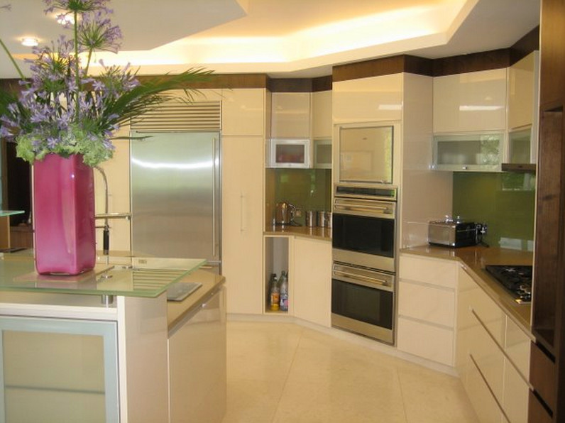 Mid-sized traditional u-shaped open plan kitchen in Perth with a drop-in sink, flat-panel cabinets, white cabinets, solid surface benchtops, green splashback, glass sheet splashback, stainless steel appliances, ceramic floors and with island.