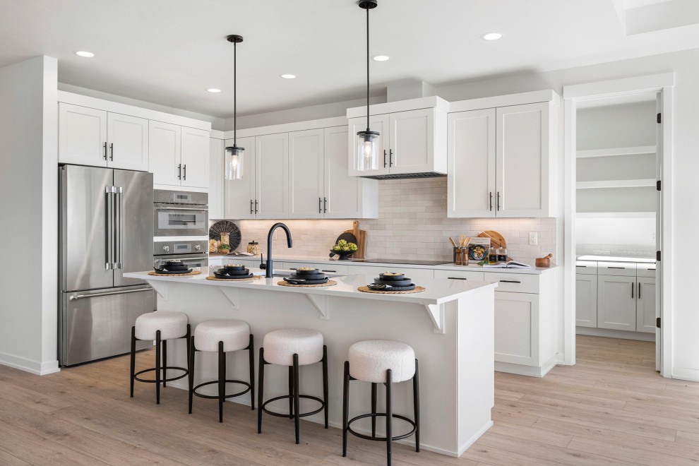Transitional l-shaped eat-in kitchen photo with an island