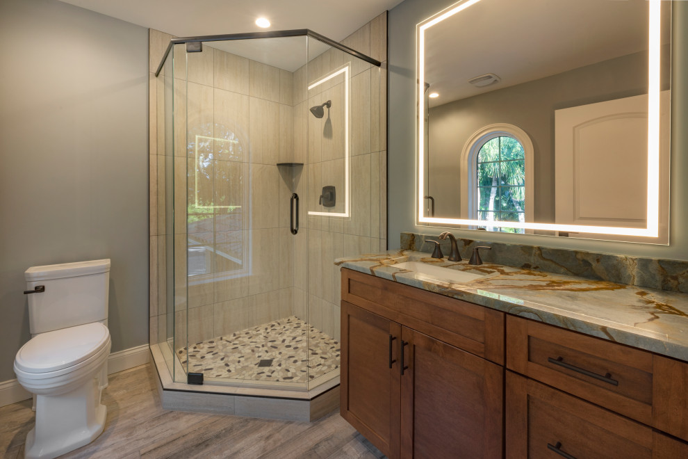 Photo of a large contemporary master bathroom in Tampa with beaded inset cabinets, medium wood cabinets, a japanese tub, a corner shower, a one-piece toilet, vinyl floors, an undermount sink, engineered quartz benchtops, brown floor, a hinged shower door, multi-coloured benchtops, a double vanity and a built-in vanity.