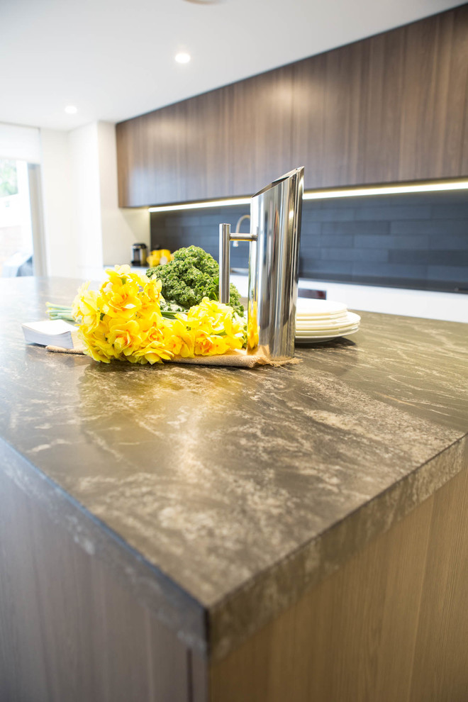 Large modern single-wall kitchen pantry in Sydney with a drop-in sink, flat-panel cabinets, medium wood cabinets, granite benchtops, black splashback, ceramic splashback, stainless steel appliances, ceramic floors, with island and grey floor.