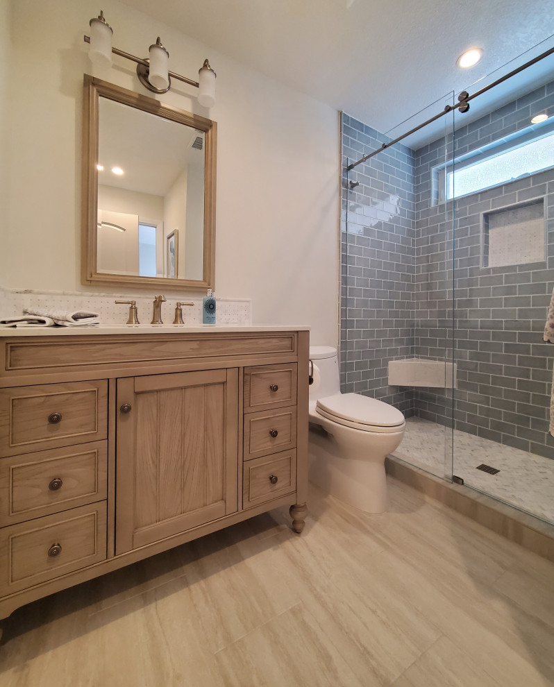 Photo of a small bathroom in Orange County with medium wood cabinets, an alcove shower, a one-piece toilet, porcelain tiles, porcelain flooring, a submerged sink, engineered stone worktops, beige floors, a sliding door, white worktops, a single sink, a freestanding vanity unit and recessed-panel cabinets.