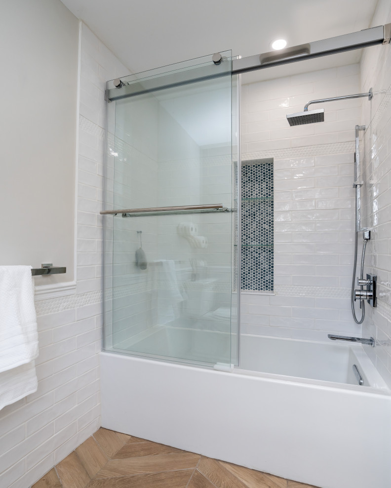 This is an example of a large nautical family bathroom in Boston with shaker cabinets, blue cabinets, an alcove bath, an alcove shower, white tiles, metro tiles, wood-effect flooring, engineered stone worktops, beige floors, a sliding door, white worktops, double sinks and a freestanding vanity unit.