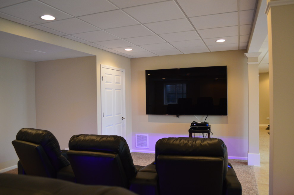 Photo of a mid-sized traditional open concept home theatre in Chicago with brown walls, carpet, a wall-mounted tv and brown floor.