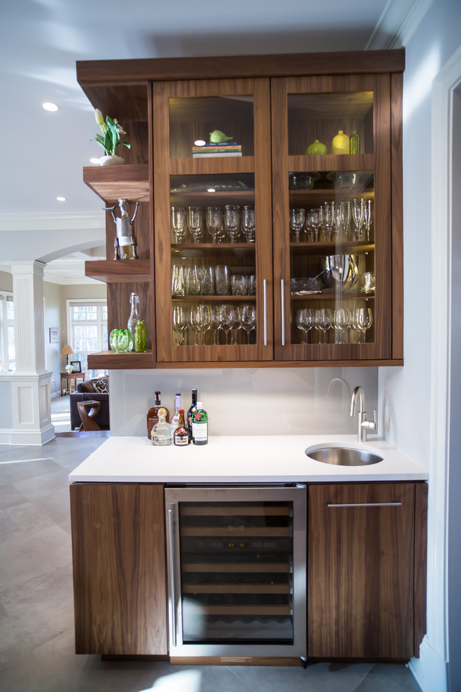 Example of a large transitional gray floor open concept kitchen design in DC Metro with an undermount sink, glass-front cabinets, medium tone wood cabinets, beige backsplash, stainless steel appliances and an island