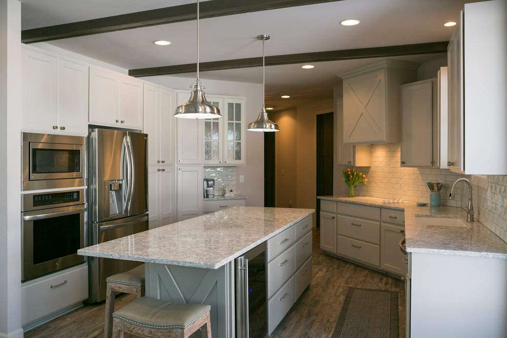 Example of a mid-sized mountain style l-shaped medium tone wood floor open concept kitchen design with an undermount sink, raised-panel cabinets, white cabinets, granite countertops, white backsplash, subway tile backsplash, stainless steel appliances, an island and gray countertops