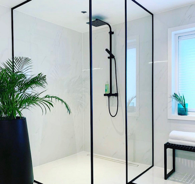This is an example of a medium sized contemporary ensuite bathroom in New York with shaker cabinets, beige cabinets, a freestanding bath, a built-in shower, a wall mounted toilet, multi-coloured tiles, porcelain tiles, porcelain flooring, a submerged sink, marble worktops, an open shower, white worktops, double sinks and a floating vanity unit.