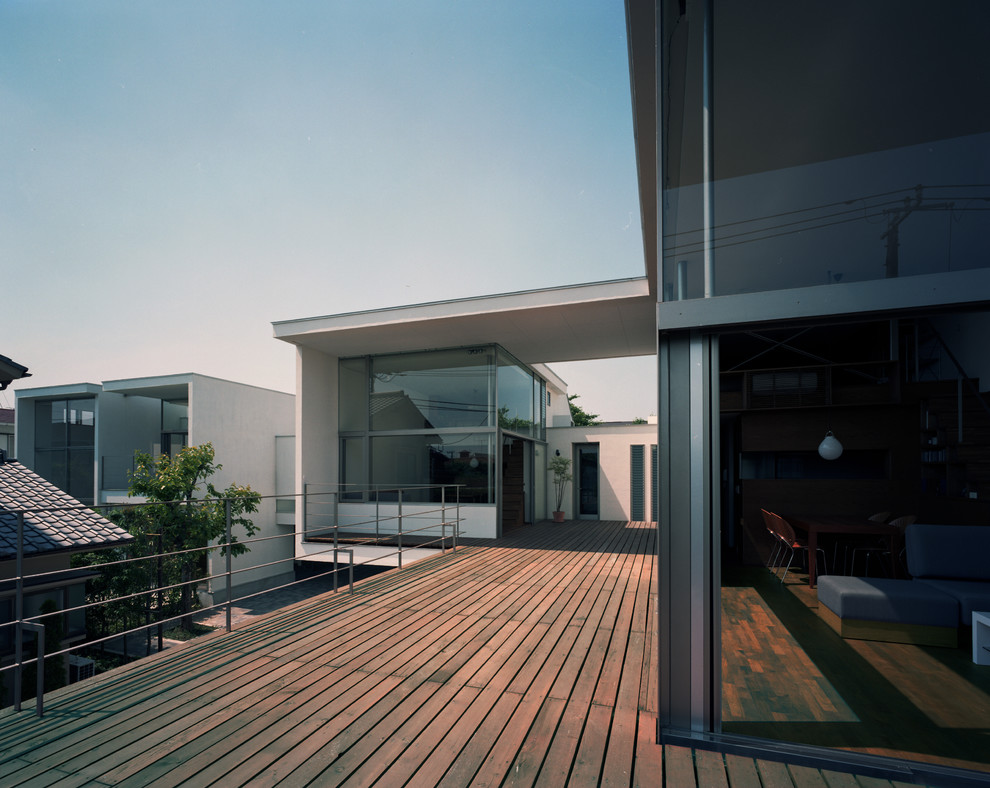 Ispirazione per una grande terrazza minimalista sul tetto con un tetto a sbalzo