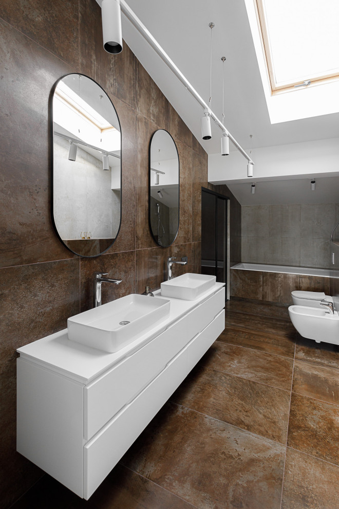 Пример оригинального дизайна: большая главная ванная комната: освещение в современном стиле с фасадами островного типа, белыми фасадами, открытым душем, раздельным унитазом, коричневой плиткой, мраморной плиткой, бежевыми стенами, мраморным полом, накладной раковиной, столешницей из искусственного камня, бежевым полом, душем с раздвижными дверями, белой столешницей, тумбой под одну раковину, подвесной тумбой и панелями на стенах