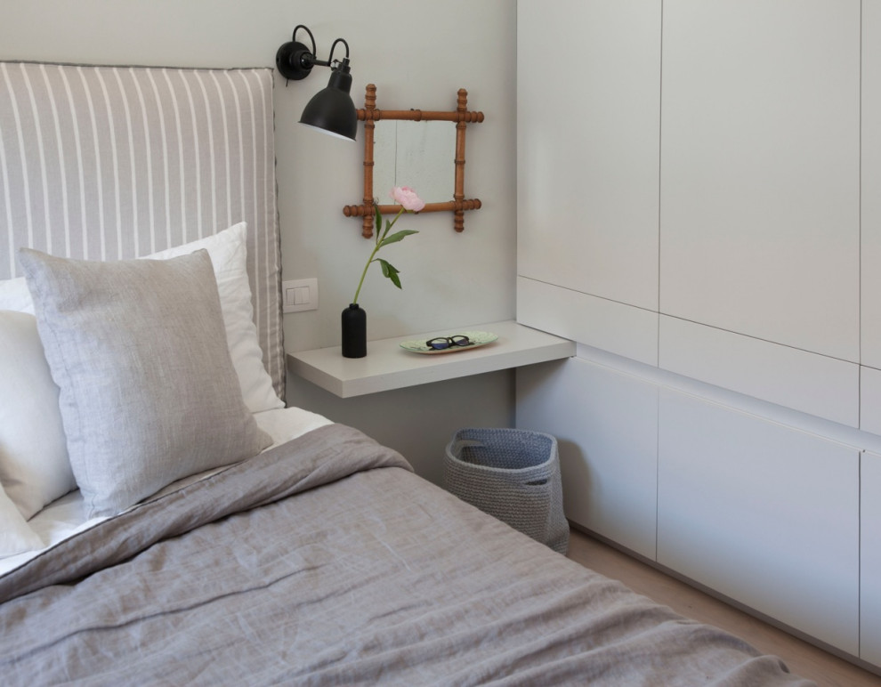 Foto de dormitorio actual de tamaño medio con paredes beige y suelo de madera clara