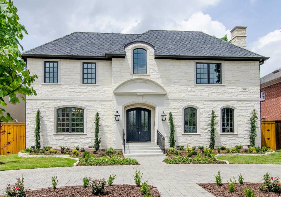 Photo of a mid-sized transitional two-storey beige exterior in Dallas with stone veneer and a hip roof.