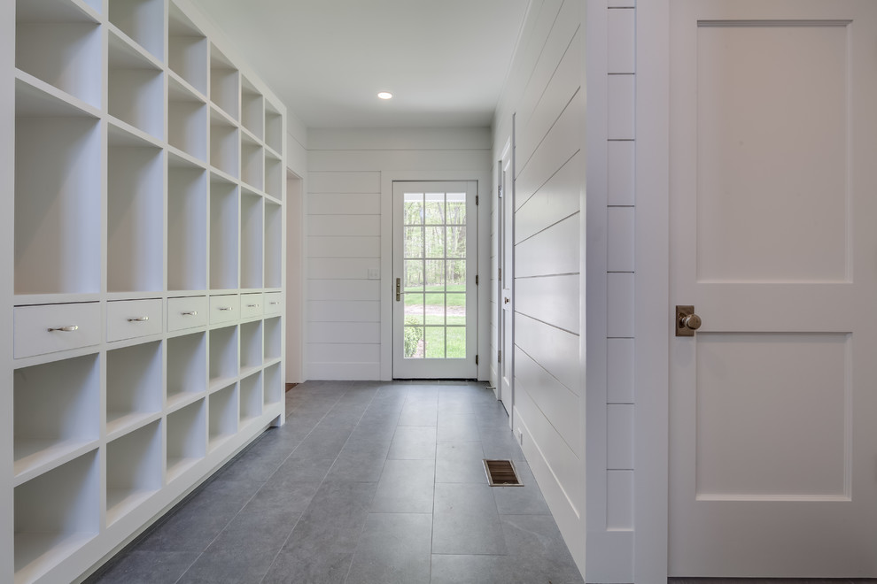 Mudroom - huge transitional gray floor mudroom idea with white walls and a glass front door