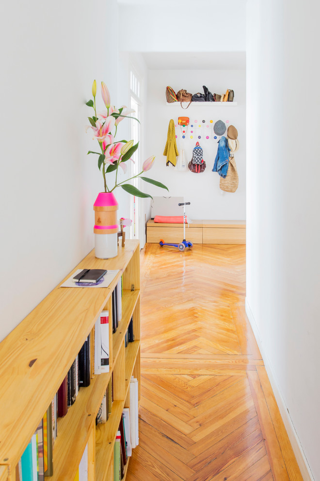 Photo of a small scandinavian hallway in Madrid with white walls and medium hardwood floors.