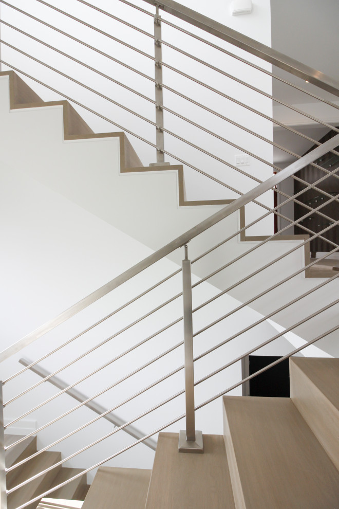 Стильный дизайн: деревянная лестница на больцах, среднего размера в стиле модернизм с деревянными ступенями, металлическими перилами и стенами из вагонки - последний тренд