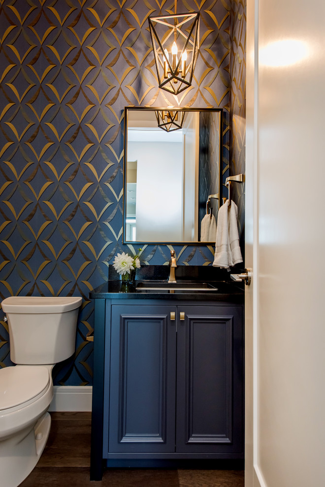 Inspiration for a small traditional powder room in Other with recessed-panel cabinets, blue cabinets, blue walls, dark hardwood floors, an undermount sink, granite benchtops, brown floor, black benchtops and a two-piece toilet.