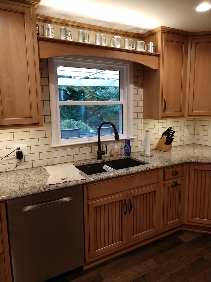 Inspiration for a mid-sized rustic laminate floor and multicolored floor home design remodel with distressed cabinets, granite countertops, white backsplash, subway tile backsplash, stainless steel appliances, no island and multicolored countertops