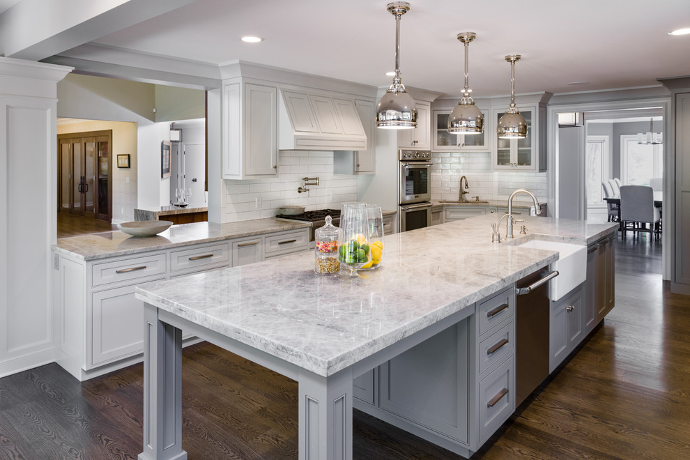 Design ideas for a large modern l-shaped separate kitchen in Cleveland with a farmhouse sink, recessed-panel cabinets, grey cabinets, white splashback, subway tile splashback, stainless steel appliances, dark hardwood floors and with island.