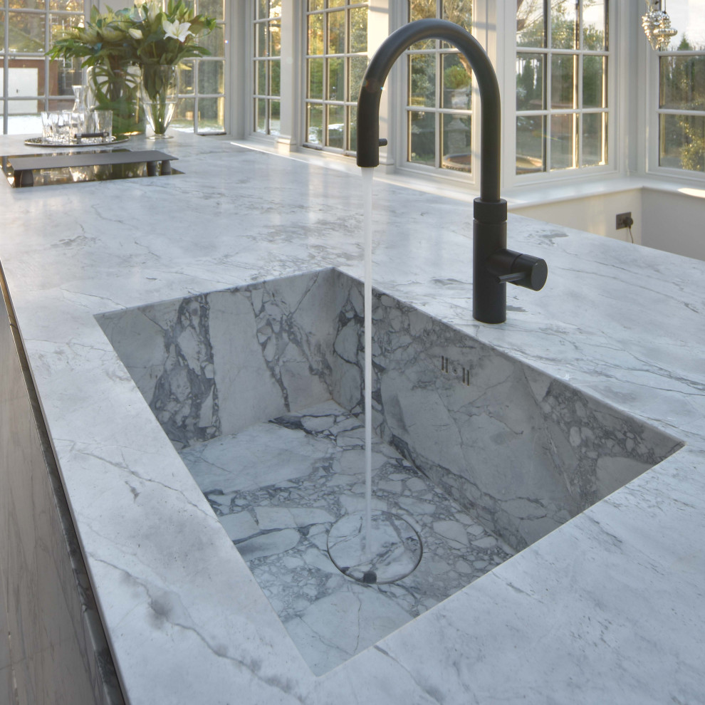 Photo of a large contemporary open plan kitchen in Manchester with an integrated sink, flat-panel cabinets, granite worktops, porcelain flooring, an island and grey worktops.