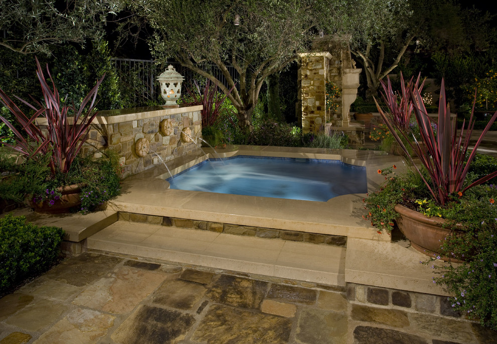 Mid-sized mediterranean backyard custom-shaped pool in Los Angeles with a hot tub and natural stone pavers.