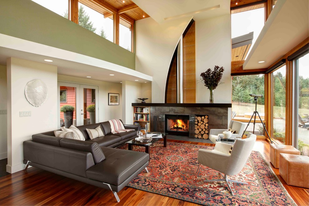 Inspiration for an expansive contemporary open concept living room in Portland with green walls, no tv, medium hardwood floors, a wood stove and a stone fireplace surround.