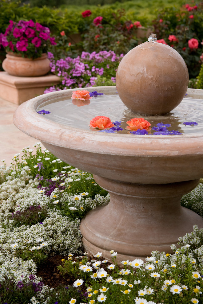 This is an example of a small traditional full sun garden in Santa Barbara with a water feature.