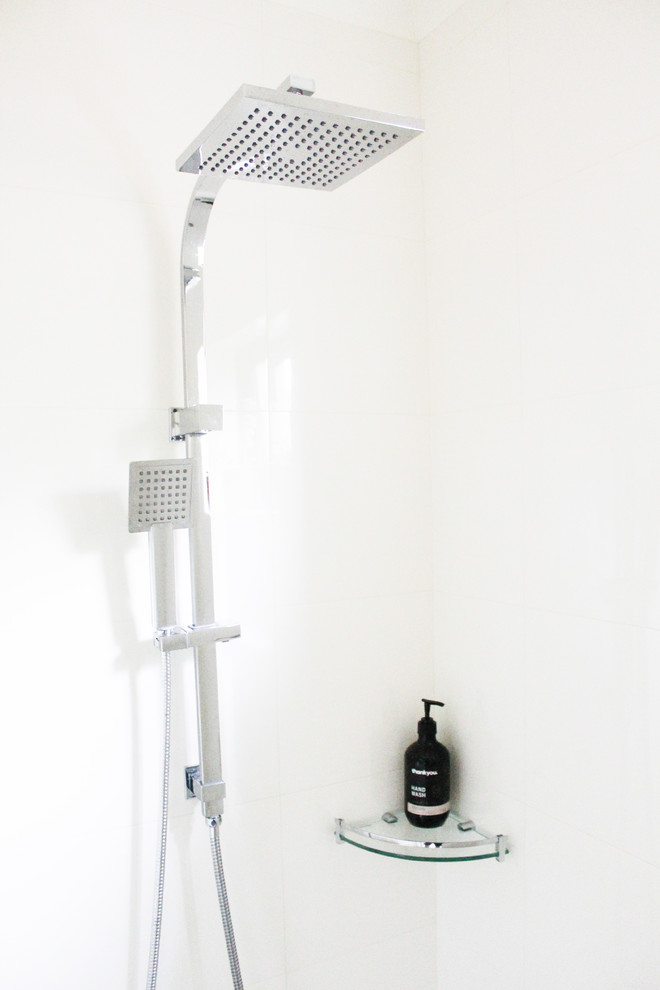 This is an example of a small 3/4 bathroom in Perth with flat-panel cabinets, light wood cabinets, an open shower, a one-piece toilet, beige tile, ceramic tile, beige walls, porcelain floors, an integrated sink, solid surface benchtops, beige floor and white benchtops.