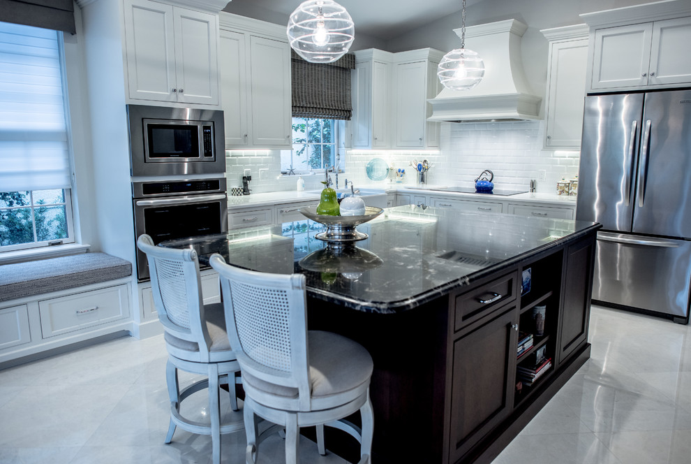 Mid-sized contemporary l-shaped open plan kitchen in Miami with a farmhouse sink, shaker cabinets, white cabinets, marble benchtops, white splashback, subway tile splashback, stainless steel appliances, porcelain floors and with island.