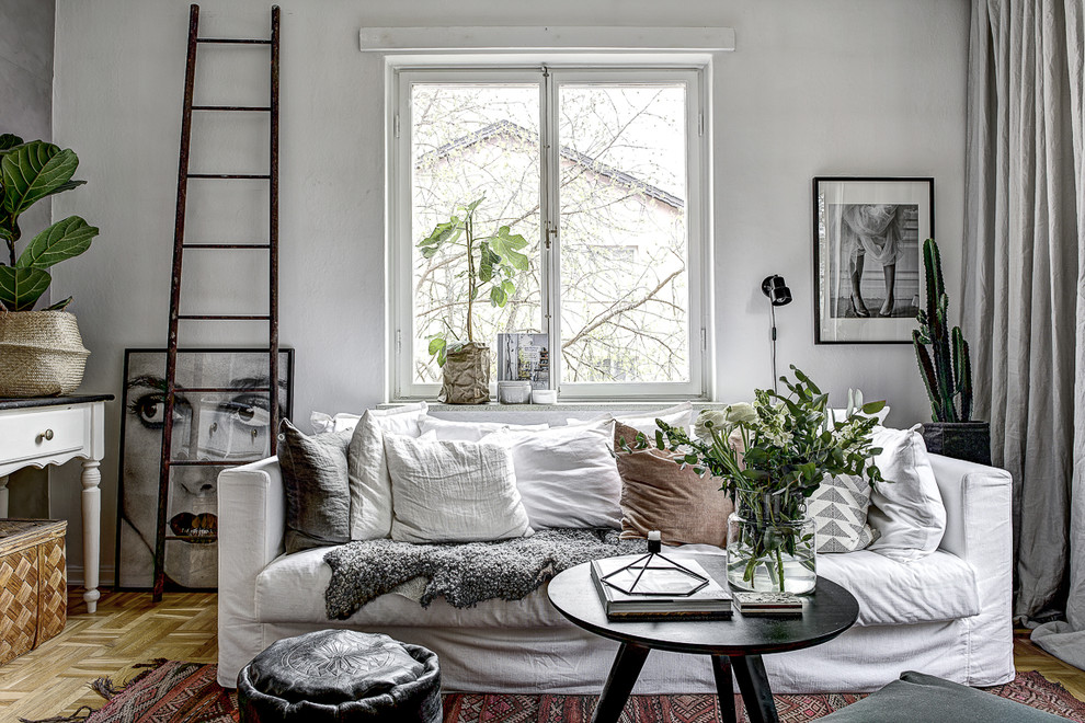 Photo of a scandinavian formal living room in Stockholm with white walls, medium hardwood floors, no fireplace and no tv.